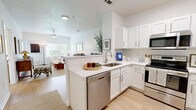 Located at 50 Saw Mill Rd in Danbury, CT, this thoughtfully designed 2-bedroom, 1-bathroom residence offers a comfortable and functional single-floor layout. The bright living room features light hardwood-style flooring, a ceiling fan, and windows that invite natural light, creating a welcoming, airy atmosphere. The kitchen is outfitted with white cabinetry, stainless steel appliances including a refrigerator, range, and microwave, and a peninsula with bar seating that connects seamlessly to the main living area — ideal for casual dining and entertaining. The spacious primary bedroom offers generous proportions with light flooring and direct access to the full bathroom, which includes a tub-shower combination, white vanity cabinetry, and tile flooring. The second bedroom provides comfortable accommodations with the same clean, neutral aesthetic found throughout the home. A dedicated laundry area with a stacked washer and dryer adds everyday convenience. Completing the space is a private outdoor balcony overlooking lush green surroundings and neighboring rooftops — a peaceful retreat for relaxing outdoors.