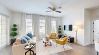 Located in Fort Myers, FL, this well-appointed two-bedroom, two-bathroom home spans two floors, with the majority of the living space situated on the upper level. The bright and airy living room is a standout feature, showcasing luxury vinyl plank flooring, large windows with plantation shutters that invite abundant natural light, and a ceiling fan. The open layout flows comfortably from living to dining areas, creating a welcoming atmosphere throughout.

The kitchen is outfitted with white shaker cabinetry, dark hardware accents, stainless steel appliances including a French door refrigerator and range, a mosaic tile backsplash, and sleek countertops. Both bathrooms feature marble-style tile finishes — the primary bath includes a glass-enclosed walk-in shower, while the secondary bath offers a tub-shower combination, each with a single vanity and modern black fixtures.

The primary bedroom is generously sized with plush carpeting, multiple windows, and access to a walk-in closet with built-in wire shelving. The second bedroom is equally bright with carpet flooring and its own closet. Additional highlights include an in-unit laundry area, a dedicated hallway, and a private garage with concrete flooring on the ground level, providing secure parking and extra storage.