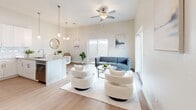 Located at 4630 N 23rd Ave in Phoenix, AZ, this two-story residence offers 2 bedrooms, 4 bathrooms, and a well-planned layout spread across two floors. The main level opens into a bright, airy living area with high ceilings, a ceiling fan, and large sliding glass doors that invite abundant natural light. The open-concept kitchen flows seamlessly into the living space and features white shaker cabinetry, a subway tile backsplash, stainless steel appliances including a French door refrigerator and over-the-range microwave, and a spacious island with a quartz countertop and bar seating illuminated by pendant lighting — ideal for both cooking and entertaining. Light wood-tone flooring runs throughout, lending warmth and continuity to each space. The upper floor houses the generously sized primary bedroom, complete with a ceiling fan, a dedicated closet with built-in shelving, and a private en-suite bathroom featuring a dual-sink vanity with quartz countertops and a walk-in shower. Additional bathrooms maintain the same clean, modern aesthetic with white cabinetry, quartz surfaces, and tub-shower combinations. A dedicated in-unit laundry room with full-size washer and dryer adds everyday convenience. The secondary bedroom is well-proportioned and equally bright, completing this thoughtfully designed home.