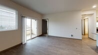 Located at 709 153rd Pl SW in Lynnwood, Washington, this well-appointed unit offers a thoughtfully designed single-floor layout that blends modern finishes with functional living spaces. The open-concept living area features durable wood-look flooring, neutral walls, and sliding glass doors that lead to a private balcony, allowing natural light to flow freely throughout. The bedroom is carpeted for comfort and includes a ceiling fan, multiple windows with blinds, and pleasant outdoor views of the surrounding neighborhood. The kitchen is a standout feature, equipped with light wood-grain cabinetry, sleek quartz countertops, a glass tile backsplash, and a full suite of stainless steel appliances including a range, dishwasher, microwave, and refrigerator. A central island provides additional prep space and adds to the open, airy feel of the layout. Two bathrooms serve the unit — one featuring a tub/shower combo with tiled surround, and another with a walk-in glass-door shower, modern vanity lighting, and wood-look tile flooring. Throughout the unit, clean lines, recessed lighting, and a cohesive neutral palette create a fresh, contemporary atmosphere well-suited for comfortable everyday living.
