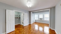 Located at 1301 15th St NW in Washington, DC's vibrant Logan Circle neighborhood, this efficiently designed studio unit offers a well-considered layout across a single floor. The living area immediately draws attention with its beautifully polished parquet wood flooring arranged in a classic basket-weave pattern, which extends throughout the space and adds warmth and timeless character. Soft gray walls complement the light-toned trim and white baseboards, creating a clean, neutral palette throughout. A bank of windows in the living area allows natural light to filter in, brightening the interior and providing views of the surrounding urban streetscape. A ceiling fan fixture provides additional comfort. The kitchen is positioned to maximize the use of the compact footprint, offering functional workspace. The walk-in closet features built-in shelving and a hanging rod, providing organized and practical storage. The bathroom showcases a classic black-and-white subway tile design with bold black accent trim, a soaking tub, and a windowed surround that adds natural light to the space. A traditional radiator is also present, underscoring the building's historic character. Overall, the unit presents a cohesive, well-maintained interior with a blend of classic architectural detail and practical functionality.