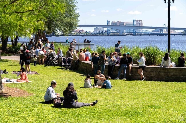 People enjoy the sunshine by the St. Johns River next to the Riverside Arts Market.