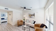 Located in Baton Rouge, Louisiana, this efficiently designed two-bedroom, one-bathroom unit offers a clean, modern aesthetic throughout its single floor. Light wood-style flooring runs continuously across all rooms, creating a cohesive and airy feel.

The combined kitchen and living area serves as the heart of the unit. The kitchen is outfitted with gray shaker-style cabinetry, stainless steel appliances including a refrigerator and dishwasher, a single-basin sink, and light countertops, with recessed lighting overhead. A dining area sits adjacent to the kitchen, providing a dedicated space for meals.

The living room benefits from large windows with horizontal blinds that allow natural light to fill the space. A modern ceiling fan with an integrated light fixture adds comfort and style. The room offers a welcoming layout suited for relaxed living.

The primary bedroom features a window for natural light, a ceiling fan, and a closet with built-in shelving. The second bedroom also includes a window and demonstrates flexible use with twin bed accommodations.

The bathroom is neatly appointed with a shower-tub combination, a gray vanity with a white countertop, and a frameless mirror. A hallway connects all rooms, contributing to a practical and organized flow throughout the unit.