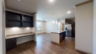 This single-floor residence offers a thoughtfully designed open-concept layout that seamlessly connects the kitchen, dining, and living areas. The kitchen is a standout feature, showcasing dark espresso cabinetry, granite countertops, stainless steel appliances, and a central island with a built-in sink and pendant lighting overhead. Rich hardwood-style flooring flows throughout the main living areas, complemented by crown molding and recessed lighting that add a refined touch. A built-in shelving nook with granite countertop provides additional storage and workspace off the main living area.

The bedrooms are carpeted for comfort and each features a ceiling fan, ample natural light from large windows with blinds, and walk-in closets with built-in shelving and hanging rods. The primary bathroom is appointed with a double vanity featuring granite countertops, dark wood cabinetry, framed mirrors, and a glass-enclosed shower. A secondary full bathroom includes a tiled tub-shower combination with a curved curtain rod and hardwood-style flooring. Throughout the residence, the neutral color palette and quality finishes create a clean, cohesive, and inviting atmosphere.