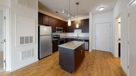 Located at 1230 Jabbers Dr, Unit 402, in Mount Pleasant, SC, this single-floor residence combines modern finishes with a functional, comfortable layout. The kitchen serves as a central highlight, featuring rich dark-espresso cabinetry, granite countertops, a center island with pendant lighting, stainless steel appliances including a refrigerator, range, microwave, and dishwasher, and warm hardwood-style flooring. Track lighting overhead enhances both functionality and ambiance in this well-equipped space.

The bedrooms are carpeted for comfort and each includes a ceiling fan with light kit and windows fitted with blinds that allow for natural light while maintaining privacy. The rooms are designed with clean, neutral walls and offer a spacious, open feel. One bedroom features access to a walk-in closet, adding practical storage.

The bathrooms are finished with tile flooring, dark vanity cabinetry, granite countertops, and tub-shower combinations accented by curved chrome curtain rods and white mosaic tile surrounds. The overall aesthetic throughout the unit is clean and contemporary, with a neutral palette that creates a bright, inviting atmosphere well-suited to everyday living.