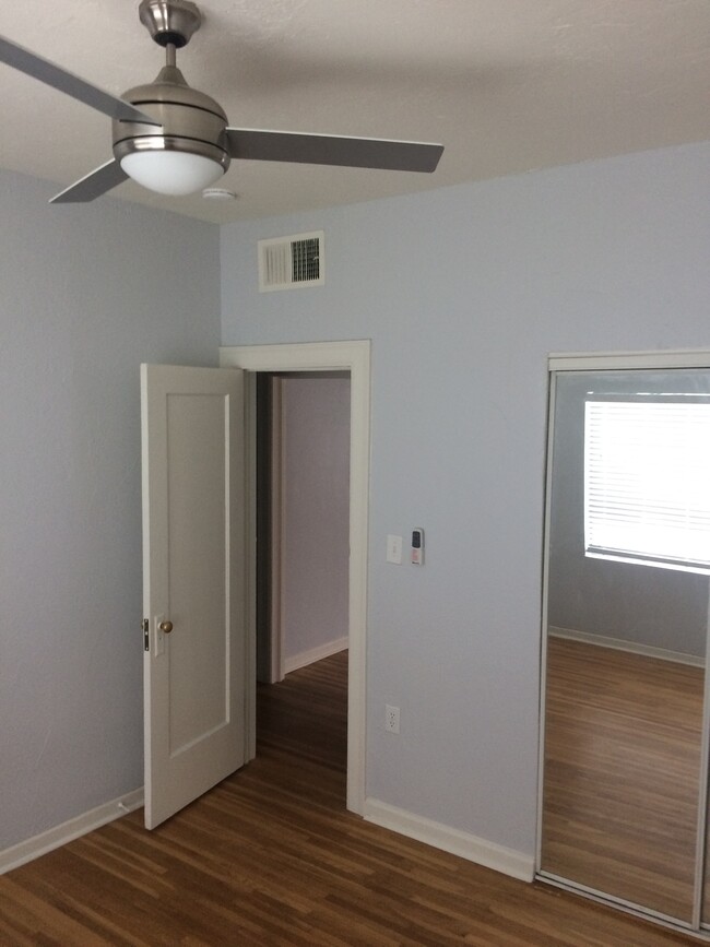 Downstairs bedroom view from far corner. On the right the mirrors are part of closet. New ceiling fan. - 1819 North Laurel Avenue