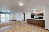 Located at 5730 Leubecher Ave in Sioux Falls, SD, this three-bedroom, two-bathroom apartment offers a well-designed single-floor layout. The open-concept living and kitchen area forms the heart of the space, featuring light luxury vinyl plank flooring that flows seamlessly throughout. The kitchen is equipped with dark espresso cabinetry, a peninsula with a double-basin sink and light countertops, and a full suite of black appliances including a refrigerator, electric range, and over-the-range microwave. The adjacent living room transitions to plush carpeting and features a sliding glass door with vertical blinds that opens to a balcony, allowing natural light to fill the space. Each of the three bedrooms is carpeted and includes a window with views of the surrounding area, providing natural light and a sense of openness. The primary bedroom offers a comfortable, well-proportioned layout. Both bathrooms are finished with wood-tone vanities, stone-look countertops, and LVP flooring, providing a consistent and cohesive aesthetic. Textured ceilings and warm wood-tone baseboards throughout add a clean, finished look to every room in this functional and practical Sioux Falls residence.