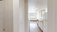 This single-floor, 2-bedroom, 1-bathroom unit in Albany, Oregon offers a functional and well-organized layout designed to maximize everyday comfort. The galley-style kitchen is efficiently arranged with light wood cabinetry, laminate countertops, wood-style flooring, and white appliances including a coil-top range, refrigerator, and dishwasher. The kitchen opens into a dining area bathed in natural light from a large window, accented by a classic chandelier overhead. Both bedrooms feature neutral carpet flooring, clean white walls, and closet storage. The primary bedroom includes a spacious double sliding-door closet, while the second bedroom benefits from a wall-mounted heater and a window overlooking the surrounding neighborhood. A third carpeted room provides additional flexible space with its own closet. The full bathroom is finished with wood-style flooring, a single-sink vanity with light blue countertops and under-sink storage, and a shower-tub combination with grab bars. Throughout the unit, flush-mount ceiling light fixtures provide consistent, even lighting. The overall aesthetic is clean, bright, and move-in ready, with a neutral color palette that lends itself well to personalization.