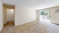 Located at 1860 52nd St E in Inver Grove Heights, MN, this one-bedroom, one-bathroom unit offers a well-organized and efficient layout across a single floor. The living area is finished with neutral-toned carpet and painted in light, warm hues, creating a clean and inviting atmosphere. A sliding glass door floods the space with natural light and opens to a private balcony with outdoor views, adding a pleasant sense of openness to the room. Textured ceilings are featured throughout the unit.

The galley-style kitchen is efficiently designed with white cabinetry accented by warm wood trim, white appliances including a range, microwave, and refrigerator, and a double sink. Tile flooring and ample cabinet storage make the kitchen both practical and easy to maintain.

The bedroom is a comfortable, well-proportioned retreat featuring plush carpeting, a ceiling fan with a light fixture, a window overlooking lush greenery, and a closet with classic six-panel doors. The bathroom includes a full tub-and-shower combination with clean white surround panels, offering a simple and functional design. Overall, the unit presents a tidy, move-in-ready space suited for comfortable everyday living.
