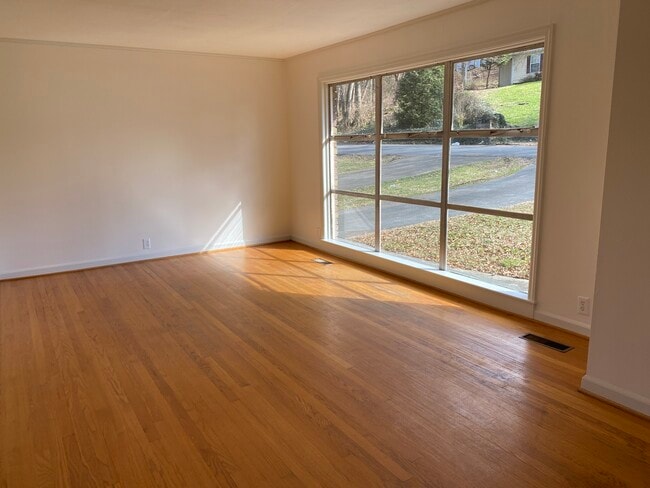 Large picture window in the living room, hardwood floors throughout. - 411 Brown Ave NW