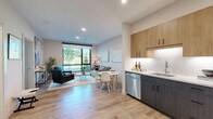 Located at 250 Water St in Williamstown, Massachusetts, this thoughtfully designed one-bedroom, one-bathroom residence offers a well-appointed single-floor layout with modern finishes throughout. Light wood-tone flooring flows seamlessly across all rooms, creating a cohesive and inviting atmosphere.

The open-concept living area is anchored by a large picture window that frames views of the surrounding greenery, filling the space with natural light. The living room comfortably accommodates both a seating area and a dining space, making efficient use of the layout.

The kitchen features a two-tone cabinetry design, pairing warm wood upper cabinets with dark lower cabinets, complemented by white quartz countertops, a subway tile backsplash, and a full suite of stainless steel appliances including a refrigerator, range, microwave, and dishwasher.

The bedroom offers a calm retreat with dual floor-to-ceiling windows overlooking trees, providing an abundance of natural light. It includes direct access to a dedicated walk-in closet equipped with wire shelving and hanging rods for generous storage.

The bathroom features large-format gray tile flooring, a clean white palette, and a wood-accented vanity, creating a modern yet warm aesthetic. The space as a whole reflects contemporary design with practical functionality.