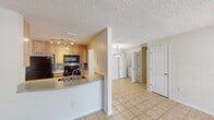 This contemporary apartment offers 850 square feet of well-designed living space. The layout includes two bedrooms and two full bathrooms, with the primary bedroom boasting a generous 200 square feet. The heart of the home is an open-concept kitchen and living area, featuring tile flooring and a partial wall that separates the kitchen while maintaining an airy feel. The kitchen is equipped with light wood cabinetry, black appliances, and a tiled backsplash, offering both functionality and style.

Both bedrooms are carpeted for comfort, with the primary bedroom featuring a large window that allows natural light to flood the space. The bathrooms are fitted with modern white fixtures, including a shower/tub combination. An in-unit laundry area adds convenience to daily living.

Throughout the apartment, neutral-toned walls create a blank canvas for personalization. The use of different flooring materials - carpet in bedrooms, tile in common areas - adds visual interest and defines spaces within the open plan. Large windows in the living area and bedrooms provide ample natural light and views of the surrounding area, enhancing the overall sense of spaciousness in this well-appointed apartment.