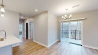 Located at 2329 SE Timberbrook Dr in Grand Rapids, MI, this thoughtfully designed 2-bedroom, 2-bathroom unit offers a clean, modern aesthetic throughout. Light-toned hardwood floors run continuously across the open layout, creating a warm and cohesive feel from room to room. The living area is bright and inviting, anchored by a contemporary chandelier and sliding glass doors that open to a private balcony overlooking the surrounding neighborhood.

The kitchen is well-appointed with crisp white shaker cabinets, white quartz countertops, a subway tile backsplash, and stainless steel appliances. A peninsula with a built-in sink and pendant lighting above adds both functionality and style, connecting the kitchen seamlessly to the living space.

Both bedrooms are comfortably sized with large windows fitted with horizontal blinds that allow for generous natural light and neighborhood views. The primary bedroom offers a practical layout with access to a closet. The two bathrooms are finished in a clean, contemporary style, each featuring wood-look flooring, white vanities, and full tub-shower combinations with brushed nickel fixtures. Neutral gray wall tones throughout the unit create a calm, move-in-ready atmosphere.