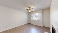 Located at 2343 W Main St in Mesa, AZ, this 2-bedroom, 2-bathroom residence offers a thoughtfully designed single-floor layout with clean, modern finishes throughout. Light wood-style laminate flooring runs consistently across the living areas and bedrooms, complementing the bright, neutral color palette that defines the space.

The combined kitchen and living area serves as the heart of the home. The kitchen is outfitted with grey shaker-style cabinetry, quartz countertops, a white subway tile backsplash, a stainless steel undermount sink, and a full suite of stainless steel appliances, including a refrigerator, range, microwave, and dishwasher. A skylight adds natural brightness overhead. The living room features a wood-burning fireplace and a ceiling fan, with a window providing natural light and outdoor views.

Both bedrooms are comfortably sized with ample natural light. The primary bedroom includes a sliding glass door leading to a private outdoor balcony and direct access to a dedicated closet. The second bedroom also features closet access. Each of the two bathrooms includes a shaker-style vanity with quartz countertops, a framed mirror with overhead lighting, and a bathtub-shower combination. Textured ceilings and clean white walls complete the crisp, move-in-ready aesthetic throughout.