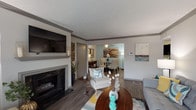 This single-floor residence at District At Hurstbourne offers a thoughtfully designed layout with cohesive finishes throughout. The living room serves as the focal point of the home, featuring a classic fireplace with a decorative mantle, wood-style plank flooring, crown molding, and a wall-mounted television. Large French doors flood the space with natural light while providing outdoor views, and the open flow leads seamlessly into a dedicated dining area equipped with a ceiling fan overhead.

The kitchen is outfitted with dark espresso cabinetry, granite-style countertops, a white subway tile backsplash, and a full suite of stainless steel appliances including a refrigerator, gas range, and built-in microwave. Wood-style flooring continues throughout this space for a consistent aesthetic.

Two bedrooms provide comfortable retreats, each featuring plush carpeting, generous closet space, and windows that bring in natural light. The neutral color palette keeps each room feeling bright and versatile.

The bathrooms mirror the kitchen's design language with dark vanity cabinetry, granite countertops, framed mirrors, and wood-style flooring. A tub-shower combination with a curtain enclosure completes the bath area, maintaining a clean, updated appearance throughout.