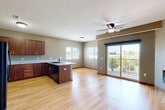 Located at 4801 N 156th Ct in Omaha, Nebraska, this two-bedroom, two-bathroom residence offers a well-designed single-level layout with a cohesive, neutral color palette and warm taupe walls throughout. The open-concept kitchen and living area serves as the heart of the home, featuring rich dark wood cabinetry, granite countertops, black appliances, and light hardwood-style flooring that extends seamlessly into the living room. The living space is bright and airy, highlighted by a built-in linear fireplace, a ceiling fan, and a sliding glass door that opens to a private balcony with open outdoor views. The kitchen provides ample storage with full upper and lower cabinetry and a functional peninsula layout. Both bedrooms are carpeted and equipped with ceiling fans, with the primary bedroom offering generous closet space via two double-door closets and a window with exterior views. The second bedroom is comfortably sized and similarly appointed. Each bathroom features granite-topped dark wood vanities and tile flooring, with the primary bath offering a walk-in shower and the secondary bath a full tub-shower combo. Three closets throughout the home provide excellent storage capacity, completing this well-appointed Omaha residence.