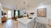 This well-designed one-bedroom, one-bathroom unit in Sherman, TX offers a thoughtful single-floor layout that maximizes every square foot. The welcoming entrance hallway, finished in crisp white with light wood-style flooring, flows naturally into the heart of the home. The open-concept kitchen and living area serves as the central gathering space, anchored by a generous kitchen island with a quartz countertop, undermount sink, and seating for multiple guests. Pendant lighting illuminates the island, while white shaker-style cabinetry, a full suite of stainless steel appliances, and a dedicated pantry complete the kitchen. The living area benefits from natural light streaming through large windows and a glass door, which opens to a private balcony. A ceiling fan overhead adds comfort to the space. The bedroom is a serene retreat, featuring a ceiling fan, a large window with ample natural light, and a closet with double doors for storage. The bathroom features a tiled tub-shower combination, a white vanity with storage, and clean, modern finishes. Additional conveniences include a dedicated laundry area, utility room, and an entrance closet, rounding out this efficiently planned and stylishly finished home.