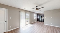 Located at 59 Port Ocall Dr in Indianapolis, Indiana, this single-story 2-bedroom, 1-bathroom home offers a practical and well-appointed layout with modern finishes throughout. The main living area features durable wood-look luxury vinyl plank flooring and neutral warm-toned walls, creating a clean and inviting atmosphere. A ceiling fan with a light fixture enhances the space, which also includes access to a closet and a front entry door.

The kitchen is efficiently designed with rich dark espresso cabinetry, light stone-look countertops, and black appliances including a refrigerator, range, and over-the-range microwave. Wood-look LVP flooring continues here, and a window provides natural light.

Both bedrooms are carpeted in a neutral tone and feature gray walls, textured ceilings, and windows that invite natural light and outdoor views. The primary bedroom includes a closet with double panel doors, offering practical storage. Both rooms provide a calm, versatile space suitable for various arrangements.

The bathroom is finished with wood-look LVP flooring, a dark-stained vanity with a white sink, matte black hardware accents, and a full tub-shower combination with white surround panels. A hallway connects the rooms, completing this efficient and move-in-ready home.