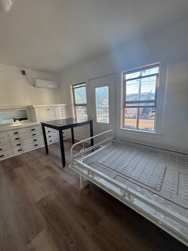 Living room with murphy bed pulled down and AC unit - 420 E 14th St