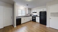 Located in the Cordova Creek community of Memphis, TN, this two-story home offers a well-designed layout with a blend of hardwood-style and carpeted flooring throughout. The main living area is a spacious, open room highlighted by a tile-surround fireplace, built-in shelving, and a ceiling fan, creating a comfortable and functional gathering space. Adjacent to the living area, a dedicated hallway leads to additional rooms and a convenient half bathroom, complete with hardwood-style flooring and a granite-style countertop vanity. The kitchen is well-appointed with white cabinetry, dark granite-style countertops, a tile backsplash, and a full suite of black appliances including a refrigerator, range, dishwasher, and overhead microhood. A window above the sink brings in natural light. The home includes multiple bedrooms, some with plush carpeting and ceiling fans, and others with hardwood-style flooring, each featuring windows with blinds for natural light. The full bathroom offers a tub-shower combination and a white vanity with a dark countertop. A dedicated laundry closet with a full-size washer and dryer adds everyday convenience. Throughout the home, textured ceilings and neutral tones contribute to a clean, move-in-ready atmosphere.