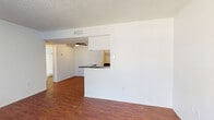 This single-floor residence offers a practical and well-organized layout with two bedrooms, two bathrooms, and three closets. The open-concept living and dining area is spacious and filled with natural light, featuring rich hardwood-style flooring, a textured ceiling, and a ceiling fan that enhances airflow throughout. A pass-through counter with a dark granite-style surface connects the living area to the kitchen, creating a sense of openness while maintaining a defined cooking space.

The kitchen is efficiently designed with white cabinetry, dark countertops, a double stainless steel sink, a dishwasher, a full-size refrigerator, and an electric range with overhead ventilation. Hardwood-style flooring continues seamlessly through the kitchen and dining areas.

Both bedrooms are carpeted and offer a quiet, comfortable atmosphere. The primary bedroom includes access to a walk-in closet with built-in shelving and hanging rods, providing generous storage. The additional bedrooms and closets throughout the unit further enhance the storage capacity.

The bathrooms feature white tile surrounds with a tub-shower combination and clean, simple fixtures. Overall, the space presents a functional and straightforward design with consistent finishes, making it a well-structured and easy-to-navigate home.