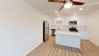 Located at 404 Encinitas Blvd in the coastal city of Encinitas, California, unit #311 is a thoughtfully designed single-floor residence that blends clean modern aesthetics with everyday functionality. Throughout the space, light-toned luxury vinyl plank flooring lends a cohesive, airy feel, while crisp white walls and ceiling fans in both the living area and bedroom promote comfort and brightness.

The open-concept kitchen is a standout feature, outfitted with white shaker-style cabinetry, quartz countertops, a stainless steel sink, and a full suite of stainless steel appliances including a refrigerator, electric range, microwave, and dishwasher. A kitchen island provides additional prep and gathering space, flowing naturally into the adjacent living area, which is bathed in natural light from a large window and offers direct access to the entry door.

The bedroom is a calm, well-proportioned retreat featuring its own ceiling fan, a window with greenery views, and ample wall space. The bathroom is finished to a high standard with white cabinetry, quartz countertops, a large vanity mirror, and a sleek walk-in shower enclosed by frameless sliding glass doors with white subway tile surround. Recessed lighting and brushed nickel fixtures complete the polished look throughout this well-appointed Encinitas residence.