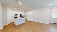 This well-designed two-story home on Azurite Way in Fort Worth, Texas offers a clean, modern aesthetic throughout its three bedrooms and three bathrooms. The main floor features an open-concept layout that seamlessly connects the living room, dining area, and kitchen. The living room is bright and airy, with light wood-look flooring, recessed lighting, a ceiling fan, and natural light streaming through blinds-fitted windows. The kitchen is a standout, showcasing white shaker cabinetry, a subway tile backsplash, quartz countertops, stainless steel appliances, a large center island with an undermount sink and pendant lighting, and an adjacent pantry for added storage. A half bath on the main floor includes a pedestal sink and clean, minimalist finishes. Upstairs, three bedrooms each feature ceiling fans, light flooring, and ample natural light, with closet access conveniently integrated. The upper level also hosts a dedicated laundry area and additional bathrooms. The attached garage provides generous storage and parking space with an automatic opener. Outside, a private, fenced backyard features a wood privacy fence, gravel landscaping, and a turf patch — ideal for low-maintenance outdoor enjoyment.