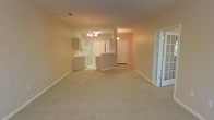 Located at 1530 Wimbledon Dr in Greenville, NC, this single-story home offers a well-designed, open-concept floor plan that creates a seamless flow between living spaces. The main living area is generously sized, featuring neutral carpet flooring and soft, warm-toned walls that lend a welcoming ambiance throughout.

The kitchen is positioned at the heart of the home and is equipped with white cabinetry, white appliances, and a peninsula-style breakfast bar that connects effortlessly to the main living and dining area — ideal for both everyday living and casual entertaining. A chandelier overhead adds a touch of character to the open space.

Natural light filters into the home through multiple entry points, including a set of elegant French doors that add architectural interest and enhance the brightness of the interior. The front entryway is clearly defined, providing a clean and functional transition into the living space.

The consistent use of neutral tones across the flooring, walls, and cabinetry creates a cohesive and versatile aesthetic throughout the home, making it easy to personalize. The single-floor layout ensures convenient, step-free accessibility across all areas of the home, offering both comfort and practicality for everyday living.