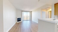 Located at 13970 Panay Way in the sought-after Marina del Rey neighborhood, this one-bedroom, one-bathroom residence offers a well-organized layout with bright, clean finishes throughout. The open-concept living and kitchen area serves as the heart of the home, featuring light wood-style flooring, neutral walls, and a standout corner fireplace with a crisp white surround. Floor-to-ceiling sliding glass doors flood the living room with natural light and open directly onto a private balcony, where sweeping views of the Marina del Rey streetscape, palm trees, and surrounding buildings create a distinctly Southern California ambiance. The galley-style kitchen is efficiently designed with warm wood cabinetry, white appliances including a gas range and dishwasher, and a dedicated pantry for additional storage. The spacious bedroom features plush carpeting, a large window with abundant natural light and neighborhood views, and mirrored sliding closet doors that enhance the sense of space. A second closet provides additional storage convenience. The bathroom is clean and functional, featuring warm wood-toned cabinetry, a white countertop vanity, and a full bathtub. Light wood-style flooring continues throughout the non-carpeted areas, tying the home together with a cohesive, modern aesthetic.