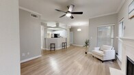 Located at 17671 Addison Rd in Dallas, TX, this 2-bedroom, 3-bathroom home offers a well-designed layout across a single floor. The open-concept living and kitchen area serves as the heart of the home, featuring light wood-style flooring, crown molding, and a ceiling fan that enhances airflow and comfort. The kitchen is outfitted with white shaker cabinetry, white quartz countertops, stainless steel appliances including a refrigerator, dishwasher, and range, plus a convenient breakfast bar that connects seamlessly to the living space. Natural light fills the interior through multiple windows dressed with blinds. Both bedrooms are generously sized, each equipped with ceiling fans and windows that bring in natural light. The primary bedroom includes a well-appointed en-suite bathroom featuring a white vanity, a large mirror with bright vanity lighting, and a glass-enclosed shower. Closets with hanging storage offer practical organization. The three bathrooms maintain a clean, neutral aesthetic with light wood-style flooring throughout. Additional highlights include a dedicated laundry area, a staircase, and an attached private garage with an automatic opener and a sealed concrete floor.