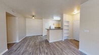 This single-floor residence offers a practical and well-organized layout designed for comfortable everyday living. The open-concept living and dining area greets you at the entry, featuring durable wood-look plank flooring and a ceiling fan with light fixture. A front door with a window panel allows natural light to filter into the living space, adding warmth to the neutral-toned walls and clean white trim.

The kitchen is a standout feature, offering generous cabinetry in a light maple finish, dark laminate countertops, and a full suite of white appliances including a range, refrigerator, dishwasher, and microwave. A peninsula counter separates the kitchen from the living area, creating an efficient and social cooking space. Built-in open shelving near the entry provides convenient storage display space.

Two well-proportioned bedrooms each include ceiling fans, wood-look flooring, and windows that bring in natural light with outdoor views. One bedroom features a closet with additional shelving visible through an open doorway. The two bathrooms are clean and functional, each offering a tub-shower combination with a curtain rod, a toilet, and one bathroom includes a vanity with a light wood cabinet and countertop. The overall ambiance is bright, neutral, and move-in ready.