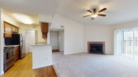 Located at 902 Delaney Cir in Brandon, Florida, this single-story home offers a well-thought-out layout with a variety of functional and comfortable living spaces. The open living area immediately draws attention with its soaring vaulted ceilings, a ceiling fan with light fixture, and a charming brick fireplace that serves as a natural focal point. Plush wall-to-wall carpeting flows through the living space, while wood-look flooring defines the adjoining dining and kitchen areas. A pass-through counter connects the living area to the galley-style kitchen, which is outfitted with warm wood cabinetry, laminate countertops, a double sink, and black appliances including a range, refrigerator, and dishwasher. Ample upper and lower cabinet storage lines both sides of the kitchen. The home includes multiple bedrooms, each featuring soft carpeting, neutral walls, and windows with blinds that allow natural light and outdoor views. The bathroom features a wood vanity with a speckle-finish countertop, a large mirror, and a tub-shower combination with tiled surround. Textured ceilings are found throughout, adding a classic residential character to the overall space.