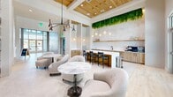 This contemporary 1920 square foot space in Fort Myers, FL, showcases a thoughtful blend of modern design and practical amenities. The single-story layout offers an open, airy feel enhanced by high ceilings and large windows that flood the interior with natural light. The living area boasts a sleek fireplace and mounted TV, creating a cozy yet sophisticated atmosphere. A striking feature is the artistic wall treatments, with some walls adorned in gradient hues that add warmth and visual interest.

The space includes a well-appointed kitchen with a central island, perfect for casual dining or entertaining. A dedicated dining area provides additional seating options. For relaxation, there are multiple seating arrangements featuring plush, curved sofas and armchairs in neutral tones. The recreation area includes a pool table, offering a space for leisure activities.

An office space with clean lines and minimalist decor caters to work-from-home needs. The bedroom, while compact at 30 square feet, likely offers essential comfort. Throughout the property, the flooring alternates between light wood and patterned carpeting, unifying the various areas while defining separate spaces. Unique lighting fixtures, including a modern chandelier and wall sconces, add character to the rooms.

Clever storage solutions, such as built-in shelving units, maximize the use of space. The overall design aesthetic favors a neutral color palette accented by natural wood tones and occasional pops of color, creating a harmonious and inviting environment that balances style with functionality.