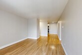 Located at 1325 Garfield St in Denver's desirable Capitol Hill neighborhood, this two-bedroom, two-bathroom residence offers a well-designed single-floor layout. Light hardwood flooring flows consistently throughout, creating a cohesive and bright atmosphere across every room.

The kitchen is efficiently arranged in an L-shaped configuration, featuring white cabinetry, light countertops, and a full suite of stainless steel appliances including a refrigerator, electric range, over-the-range microwave, and dishwasher. The adjoining living room provides an open, airy space with clean neutral walls and ample room for comfortable furnishing.

Both bedrooms are well-proportioned, each equipped with sliding double-door closets for generous storage. The primary bedroom includes a ceiling fan and a large window with vertical blinds that invites natural light and outdoor greenery views, complemented by a baseboard heating unit. The second bedroom similarly enjoys a window with outdoor views and a wall-mounted A/C unit.

The two bathrooms are clean and functional. One features a full tiled tub-shower combo with a pedestal sink and medicine cabinet mirror. The second bathroom includes a stone-toned countertop and updated fixtures. A hallway connects all rooms, completing this practical and comfortable layout.