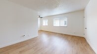 Located at 637 W 79th St in Los Angeles, CA, this single-story 2-bedroom, 1-bathroom home offers a well-organized and efficiently designed layout. Light-toned hardwood flooring flows consistently throughout every room, creating a cohesive and bright atmosphere.

The living room is a generously sized, open area featuring multiple windows with horizontal blinds that invite natural light, a ceiling fan, and a textured ceiling. A partial view of the kitchen reveals white cabinetry and granite-style countertops along the perimeter.

The two bedrooms are clean and well-lit, each featuring windows with neighborhood views. The primary bedroom includes floor-to-ceiling mirrored sliding closet doors, adding depth and brightness to the space. The second bedroom is served by a dedicated walk-in closet equipped with built-in shelving rods, offering practical storage. Both rooms feature white walls and the same warm wood flooring found throughout.

The bathroom is finished in a crisp, clean white palette with wood-look flooring, a white vanity with brushed nickel hardware, a full tub-shower combo enclosed by sliding frosted glass doors, and a grab bar for added convenience.

A hallway connects the main areas of the home, contributing to an efficient and functional flow throughout this neatly presented Los Angeles residence.