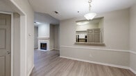 Located at 740 Sidney Marcus Blvd NE in Atlanta, GA, this single-floor residence offers a well-designed layout with a neutral color palette and durable light-toned wood-look flooring throughout the main living areas. The living room is a standout space, anchored by a classic tile-surround fireplace with a white mantel and framed by a large picture window that invites natural light and greenery views. A convenient pass-through with a granite-style ledge connects the living and dining areas to the kitchen, which is outfitted with stainless steel appliances, granite countertops, and a combination of white upper and gray lower cabinetry for a modern contrast. The bedrooms feature plush wall-to-wall carpeting and ceiling fans, with windows offering leafy outdoor views for a serene atmosphere. The bathroom presents a clean, updated aesthetic with a gray vanity, granite countertop, and a glass-enclosed shower. A dedicated laundry area with in-unit washer accommodates everyday convenience. The textured ceilings and crisp white baseboards throughout give the space a cohesive, well-maintained feel. This residence combines practical functionality with comfortable living in a prime Atlanta location.