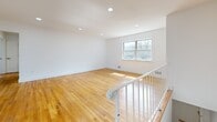 Located at 500 Adams Lane in North Brunswick, NJ, this 3-bedroom, 2-bathroom residence offers a thoughtfully designed single-floor layout. Warm hardwood flooring flows throughout the living areas and all three bedrooms, creating a cohesive and inviting atmosphere. The open living room is bright and airy, featuring recessed lighting and a large window that welcomes natural light. The kitchen stands out with its crisp white cabinetry, bold navy blue vertical tile backsplash, large-format marble-look porcelain tile flooring, and a window overlooking the exterior. It is equipped with a dishwasher and ample counter space. The spacious primary bedroom includes dual closets and generous proportions, while the additional bedrooms are well-sized, each with hardwood floors, natural light, and closet access. A sliding barn door adds a modern touch in one of the secondary bedrooms. Both bathrooms are strikingly renovated: one features a tub-shower combo with bold navy picket tile, hexagonal blue floor tile, and a wood-framed vanity mirror; the other offers a glass-enclosed walk-in shower with mosaic tile flooring and matching blue hex floor tiles. Clean white walls and recessed lighting throughout complete the modern, refreshed aesthetic of this move-in-ready home.