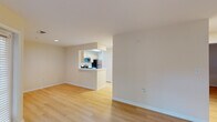 This single-floor residence offers a clean, functional layout designed for comfortable everyday living. The open-concept living area is finished with light hardwood flooring that extends throughout the space, creating a cohesive and airy feel. Neutral, warm-toned walls complement the bright interiors, while large windows fitted with horizontal blinds allow generous natural light to fill each room.

The kitchen is positioned at the heart of the home and features a peninsula-style counter that opens to the living area. Light maple cabinetry provides ample storage, while white countertops offer a clean workspace. Stainless steel appliances, including a gas range and over-the-range microwave, complete the kitchen.

The living room is generously proportioned, with multiple windows and a door providing direct access to an outdoor area, enhancing both ventilation and connectivity to the exterior.

The bedrooms are well-sized, each benefiting from large windows that invite natural light and offer views of the surrounding greenery. The hardwood flooring continues into these rooms, maintaining a consistent aesthetic throughout.

The bathroom is neatly appointed with a wood-toned vanity cabinet, white countertop, a large wall mirror, and a full tub-shower combination. The space is efficiently laid out and well-lit with overhead vanity lighting. Overall, this residence presents a bright, clean, and move-in ready environment.