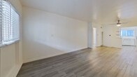 Located at 4115 Palmwood Dr, Unit 3, Los Angeles, CA 90008, this 1-bedroom, 1-bathroom apartment offers 630 square feet of efficiently designed single-floor living space. Throughout the unit, consistent gray-toned hardwood-style flooring and crisp white walls create a clean, cohesive aesthetic.

The combined kitchen and living room serves as the heart of the unit. The living area is open and well-lit, featuring a front-facing window that allows natural light to fill the space. The kitchen is equipped with a stainless steel gas range and white cabinetry, complemented by a window above the sink for added brightness and ventilation.

The bedroom spans 150 square feet and features dual windows with blinds that invite natural light, along with a ceiling fan with integrated lighting for year-round comfort. An adjacent closet provides dedicated storage. A hallway connects the main living areas to the bedroom and bathroom.

The bathroom is finished in white throughout, featuring a single-basin vanity, a full soaking tub with shower, a wall-mounted mirror with lighting, and a frosted window for privacy and natural light. The unit's straightforward layout and neutral finishes make it a practical and move-in ready space in the heart of Los Angeles.
