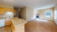 Located at 6263 19th St N in Saint Cloud, Minnesota, this single-floor unit offers a practical and comfortable layout designed for everyday living. The kitchen serves as a functional centerpiece, featuring abundant warm-toned oak cabinetry that extends to the ceiling, generous counter space, and a peninsula that provides additional prep area and separates the kitchen from the adjoining dining space. White appliances, including a refrigerator, electric range, built-in microwave, and dishwasher, are included throughout. Tile flooring runs through the kitchen, while the remaining living areas are finished with neutral-toned carpet. The dining area is illuminated by a chandelier and benefits from a sliding glass door dressed with vertical blinds, allowing natural light to fill the space. The entry features a built-in desk area with overhead cabinetry, including a decorative wine rack, alongside a full-height storage closet. Bedrooms are carpeted and include windows that bring in natural light. Bathrooms are equipped with tub-shower combinations, oak vanity cabinetry, and tile flooring. Baseboard heating is present throughout, and textured ceilings are consistent across the unit.