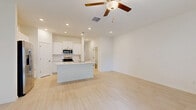 Located at 17224 Auburn Arch Loop in Wimauma, FL, this two-story home offers 2 bedrooms and 3 bathrooms thoughtfully laid out across two well-proportioned floors. The main level houses the kitchen and living room, a convenient half bathroom, and an attached garage with an automatic opener. The kitchen is outfitted with white shaker-style cabinetry, white quartz countertops, a classic subway tile backsplash, and stainless steel appliances, including a range, microwave, and dishwasher. Light wood-look tile flooring flows throughout the main living areas, contributing to a bright, airy feel. The living room features elevated ceilings, a ceiling fan, and sliding glass doors that open to a private balcony, allowing natural light to fill the space. Upstairs, the generously sized primary bedroom includes a tray ceiling with ceiling fan, plush carpet flooring, dual windows with views of the surrounding neighborhood, and a dedicated en-suite bathroom complete with a walk-in glass shower clad in large-format white tile and a vanity with white cabinetry. A spacious walk-in closet with wire shelving provides ample storage. The second bedroom is also well-sized with its own access to a full bathroom. A dedicated laundry area with a full-size washer and dryer completes the upper floor.