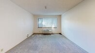 Located at 606 E Best Ave in Coeur d'Alene, Idaho, this one-bedroom, one-bathroom unit offers a straightforward and efficient layout well-suited for comfortable single-occupancy living. The living room features neutral-toned carpet, a textured ceiling, and a large window dressed with vertical blinds that allows natural light to fill the space. A wall-mounted HVAC unit provides convenient climate control. The bedroom is a well-proportioned retreat, also finished with plush carpet and a window overlooking the surrounding greenery. A full-width sliding closet offers generous storage, while an additional door provides direct access to the kitchen, which is outfitted with warm wood-toned cabinetry and functional counter space. The bathroom is designed with accessibility in mind, featuring grab bars along the walls and near the tub/shower combination, with durable vinyl plank flooring that is easy to maintain. Throughout the unit, neutral wall colors and consistent finishes create a clean, cohesive aesthetic. A ventilation unit in the living area adds to the overall practical character of the space. This unit presents a functional and accessible living environment in a convenient Coeur d'Alene location.