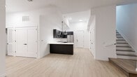 Located at 22 Schuyler Place in Morristown, NJ, this thoughtfully designed two-story residence offers 2 bedrooms and 3 bathrooms across two well-proportioned floors. The main level hosts a spacious open-concept kitchen and living area bathed in a clean, contemporary aesthetic. The kitchen is a standout feature, showcasing dark cabinetry with gold and brushed hardware, crisp white quartz countertops, a subway tile backsplash, and a full suite of stainless steel appliances including a gas range, refrigerator, dishwasher, and built-in microwave. A central island with pendant lighting anchors the space, flowing seamlessly into the living area with its light hardwood flooring and bright white walls. One bedroom on the main level features sliding glass doors that open to an outdoor area, inviting natural light and exterior views. The generously sized primary bedroom includes access to a walk-in closet with built-in shelving. The three bathrooms are finished to a high standard — one features a glass-enclosed walk-in shower with mosaic tile flooring and large-format wall tile, while another includes a soaking tub with full tile surround. The upper floor provides additional private living space, and multiple stairways connect the two levels with ease.