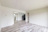 Located at 4050 Lindenwood Dr in Matteson, IL, this 2-bedroom, 1-bathroom unit offers a practical and well-organized single-floor layout. The living area is bright and open, featuring light-toned hardwood-style flooring and neutral white walls that create a clean, airy atmosphere. A sliding glass door leads to a private balcony, bringing in natural light and outdoor views of the surrounding greenery. The kitchen is efficiently designed in a galley style, outfitted with dark espresso cabinetry, light countertops, and a full suite of black appliances including a refrigerator, gas range, and overhead ventilation. Both bedrooms are carpeted for comfort, with the primary bedroom offering a spacious footprint and a sliding mirrored closet door providing convenient storage access. A dedicated closet with built-in shelving and hanging rods adds additional storage capacity. The bathroom is finished with wood-look flooring, a white vanity, and a tub-shower combination featuring large-format gray tile surround. Hallways connect the rooms efficiently throughout the unit, contributing to a cohesive and functional flow across the entire living space.