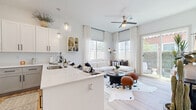 Located at 1620 N Trekell Rd in Casa Grande, AZ, this thoughtfully designed 1-bedroom, 1-bathroom single-story home offers a clean, modern aesthetic throughout. The open-concept layout seamlessly connects the kitchen, dining area, and living room, creating an efficient and inviting communal space bathed in natural light from multiple windows and a sliding glass door that opens to a private patio. The kitchen is well-appointed with crisp white upper cabinetry, contrasting gray lower cabinets, stainless steel appliances, a gleaming quartz peninsula with bar seating, globe pendant lighting, and a dedicated pantry for added storage. Light wood-tone flooring flows throughout the main living areas, enhancing the airy ambiance, while a ceiling fan keeps the space comfortable. The living area is bright and welcoming, with large windows and direct outdoor access. The bedroom is a serene retreat featuring dual windows that invite natural light, two closets, and a calm, neutral palette. The bathroom offers a white vanity, a sliding-glass walk-in shower, and light wood flooring. Additional highlights include a dedicated laundry area and entrance, rounding out a highly functional and stylish home.