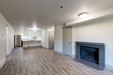 Located in Kent, WA, this well-appointed 2-bedroom, 2-bathroom residence offers a thoughtfully designed single-level layout. The open-concept living and dining area features durable hardwood-style plank flooring and a charming brick fireplace, creating a warm and inviting focal point. Sliding doors lead to a private balcony, allowing natural light to fill the space. The kitchen is efficiently designed with a galley-style layout, white upper cabinetry, dark lower cabinets, quartz countertops, stainless steel appliances including a dishwasher and range, and a peninsula that opens toward the dining area. Both bedrooms are carpeted for comfort, with the primary bedroom offering generous proportions and ample closet space. Mirrored sliding-door closets are featured in the bedrooms, maximizing both storage and the sense of space. The bathrooms are finished with wood-tone vanities, white countertops, and tub-shower combinations with brushed nickel fixtures. A hallway connects the main living areas to the private quarters, with four closets distributed throughout providing excellent storage. The neutral color palette and clean finishes throughout give the home a modern, move-in-ready feel.