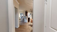 This single-story, 2-bedroom, 2-bathroom residence offers a thoughtfully designed layout that maximizes comfort and functionality. The entrance opens into a hallway that connects the key living areas, creating a seamless flow throughout the home. The open-concept kitchen and dining area is anchored by rich dark wood cabinetry, granite-style countertops, a tiled backsplash, and stainless steel appliances, including a full-size refrigerator. A breakfast bar with seating bridges the kitchen to the dining and living spaces. The living room features crown molding, hardwood-style flooring, a ceiling fan, and large windows with plantation shutters that invite generous natural light. The primary bedroom offers carpeted flooring, a ceiling fan, a bold accent wall, and ample closet space with wire shelving systems. The second bedroom mirrors this design with its own accent wall and ceiling fan. Both bathrooms are finished with dark wood vanities, granite-style countertops, and tub-shower combinations. The residence also includes three closets and a dedicated laundry room, providing excellent storage and convenience throughout.