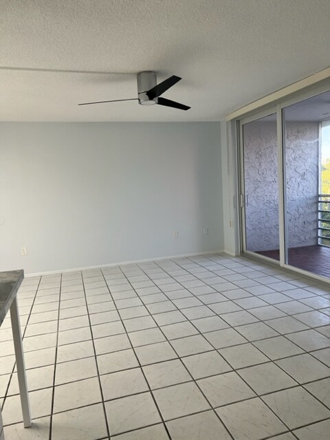 Sala de estar y puerta corrediza de impacto hacia un balcón con mosquitero - 2425 NE 135th St