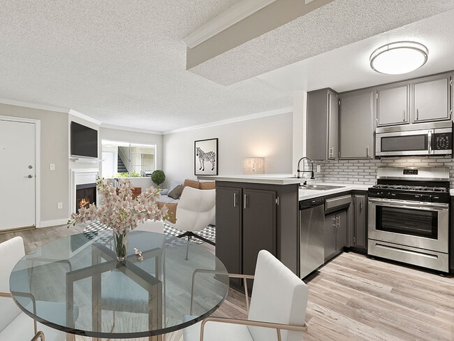 Dining room with hardwood floor and view of kitchen and living room. - Tilden Oaks