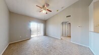 Located at 8383 El Mundo St in Houston, TX, this one-bedroom, one-bathroom unit offers a well-organized single-floor layout. The open living room is immediately welcoming, featuring vaulted ceilings that lend a sense of spaciousness, soft carpeting, and a ceiling fan with light fixture. A sliding glass door fitted with vertical blinds allows abundant natural light to pour in while providing access to an outdoor view. An elegant arched doorway connects the living area to the rest of the unit. The galley-style kitchen is efficiently designed with rich, dark wood cabinetry lining both sides, granite-look countertops, tile flooring, stainless steel appliances including a refrigerator, gas range, and built-in microwave, along with a double basin sink. A dedicated laundry area with washer and dryer hookups adds everyday convenience. The bedroom is a comfortable retreat with plush carpet, a ceiling fan, and a charming arched window that frames natural light beautifully. The bathroom is well-appointed with a wide vanity featuring granite-look counters, rich wood cabinetry, a large mirror, tile flooring, and a full tub-shower combination with tile surround. A closet and hallway complete the thoughtful layout of this Houston unit.